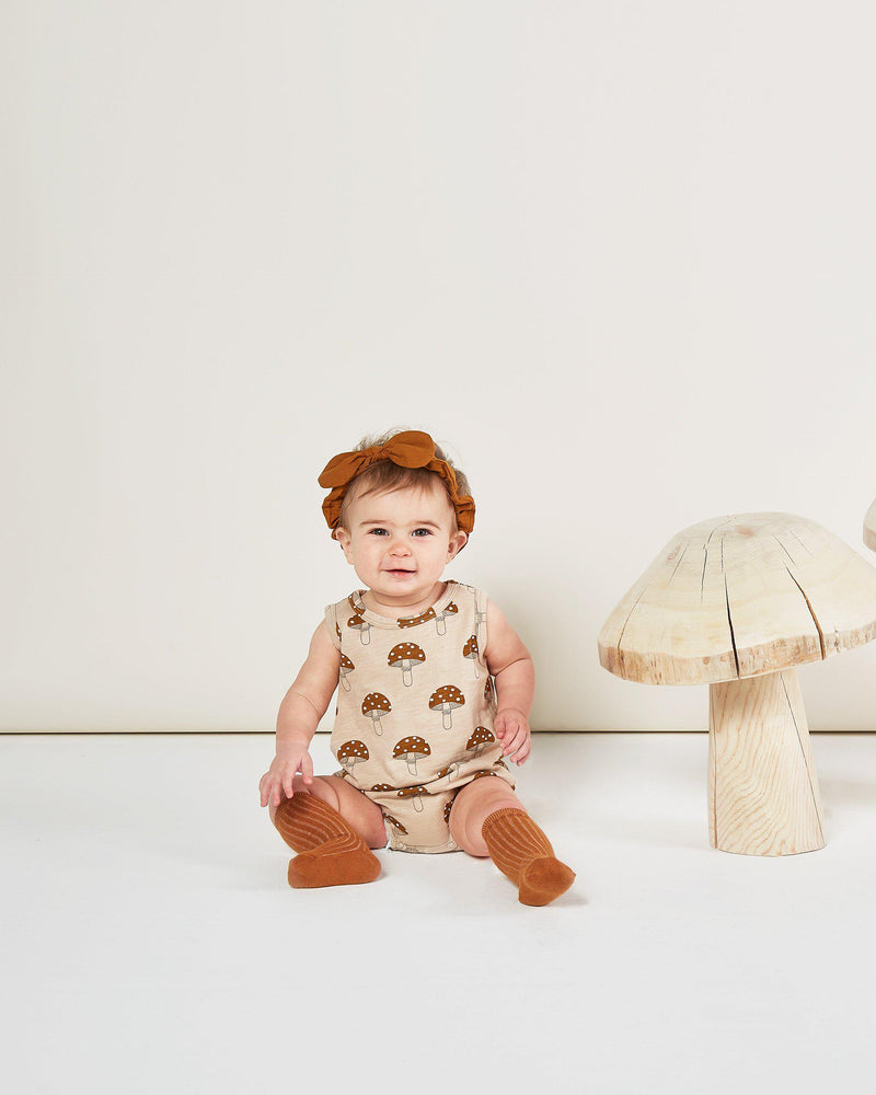 Baby in Rylee + Cru Enchanted Forest Autumn  2020 mushroom bubble romper onesie and cinnamon headband and knee socks